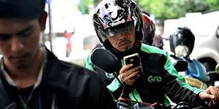 A GrabBike rider uses his mobile phone 