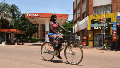 A woman rides a bicycles in Ouagadougou