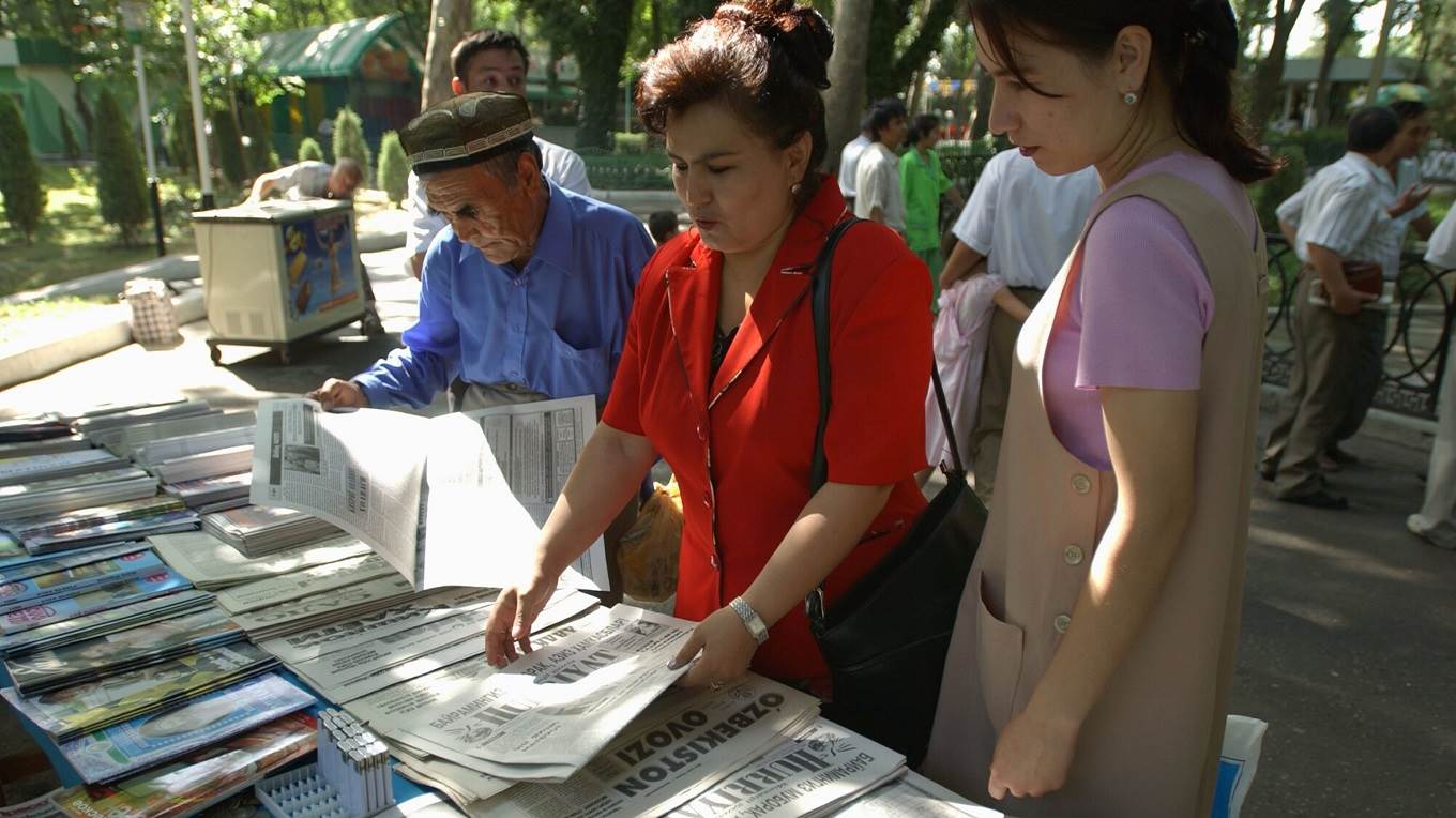 Uzbeks look at the daily sampling of newspapers