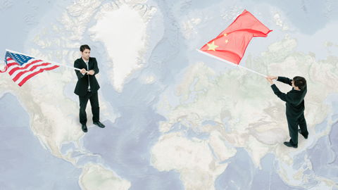 Businessmen standing on world map, waving American and Chinese flags