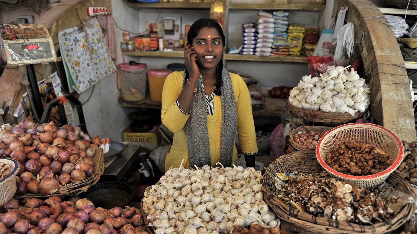 An Indian woman talks on her mobile phone at a vegetable market