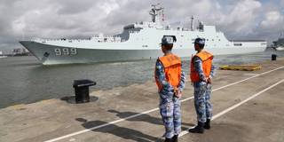 Ships carrying Chinese military personnel depart at a port 