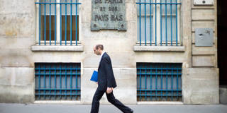 A man walks past BNP Paribas bank