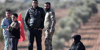 A Turkish-backed Syrian rebel fighter speaks with relatives 