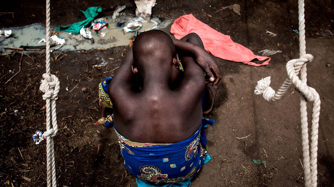 A Internally Displaced Congolese child sits on the ground at a camp for IDP