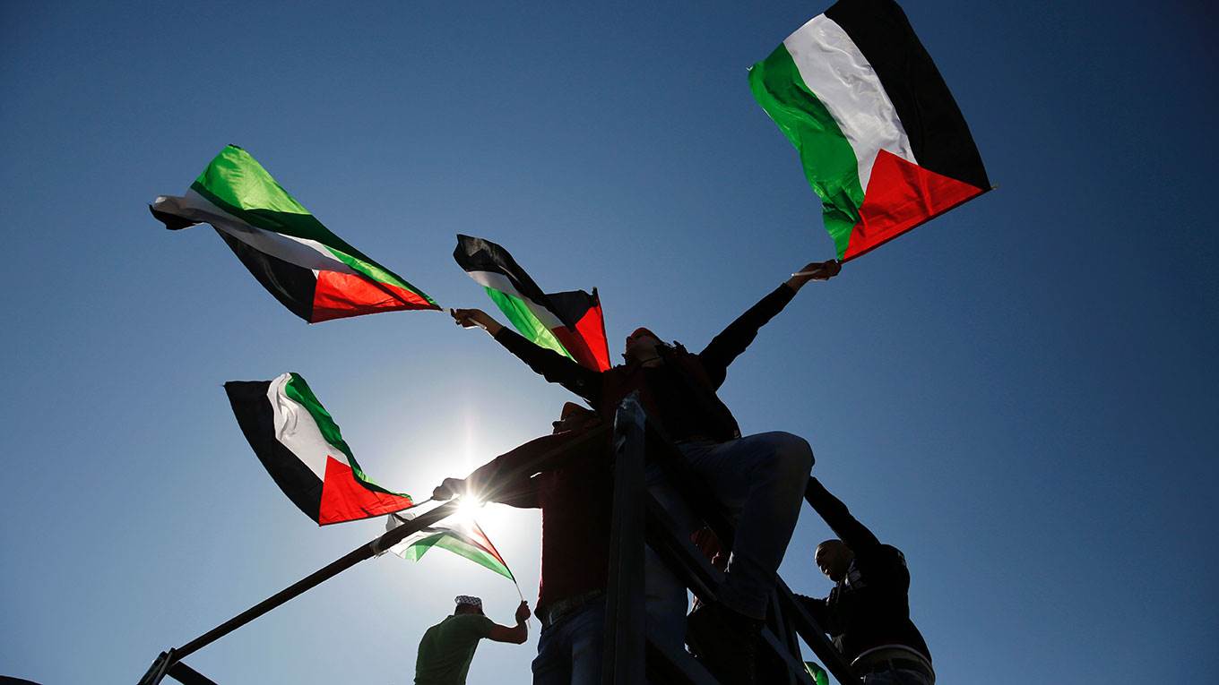 Palestinians hold national flags