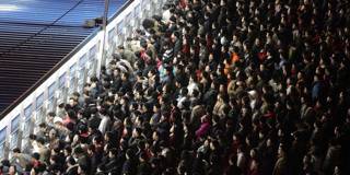 Thousands of Chinese travellers rush to buy their train tickets at the railway station in Beijing
