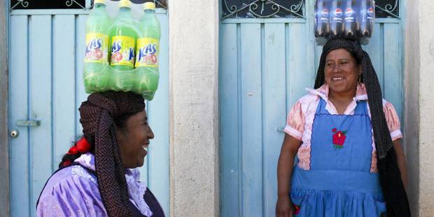 Mexican women carry soft drinks to a birthday party 