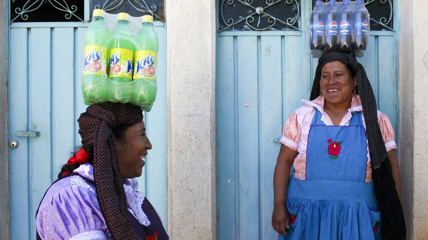 Mexican women carry soft drinks to a birthday party