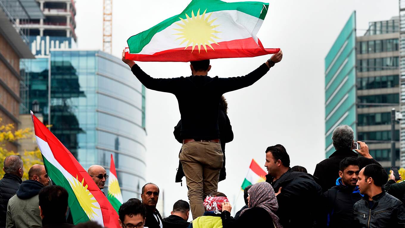 A man holds a Kurdistan's flags as he takes part in a demonstration