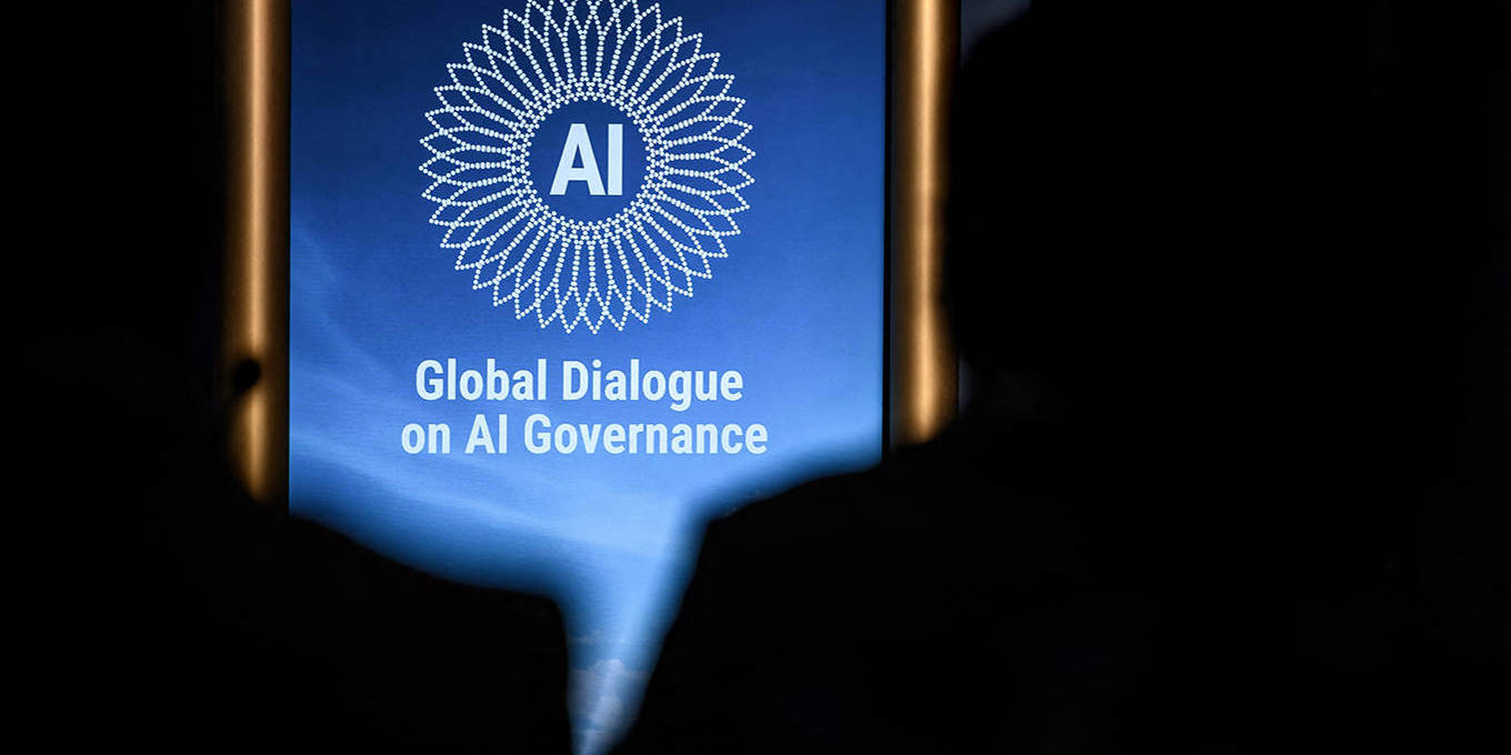 A screen displays the words “Global Dialogue on AI Governance” at an international event