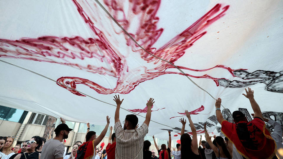 Protesters in Tirana hold a giant flamingo flag during a demonstration outside Albania&rsquo;s prime minister&rsquo;s office.