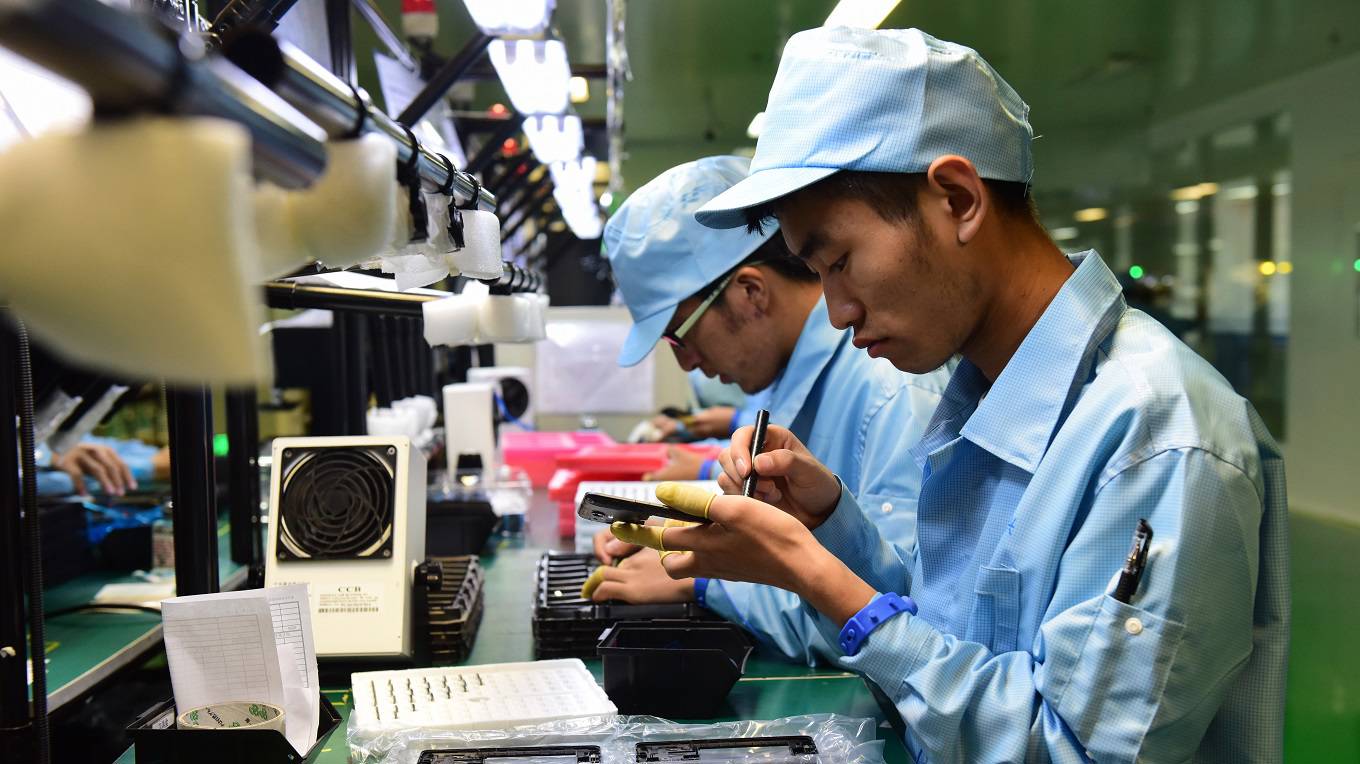 Employees work on the North America project line of smartphone at a workshop of ZTE Corp.