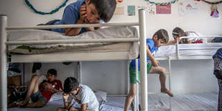 Children play in their room at a refugee camp near Belgrade