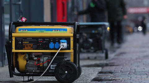 Generators operate outside shops in Dnipro, Ukraine, on January 8, 2026, as the city experiences a blackout following Russian shelling. Streets are dimly lit, and businesses rely on portable generators for electricity after power and heating outages disrupted public transport, ATMs, mobile communications, and internet service.